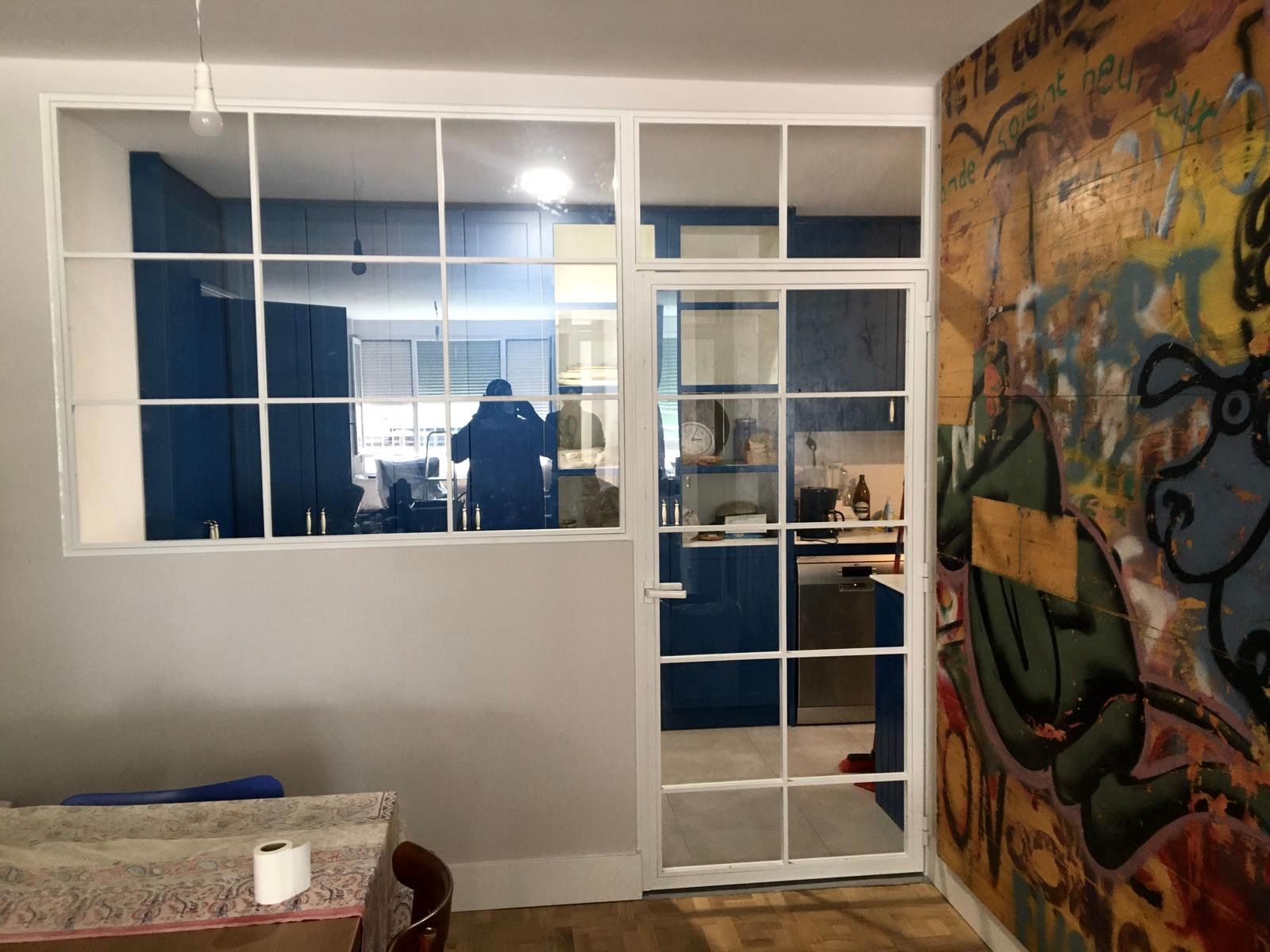 Una habitación con una mesa y sillas y una pared de graffitis.