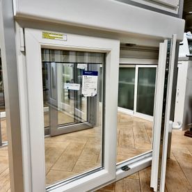 Una ventana blanca está sentada sobre un piso de madera en una habitación.