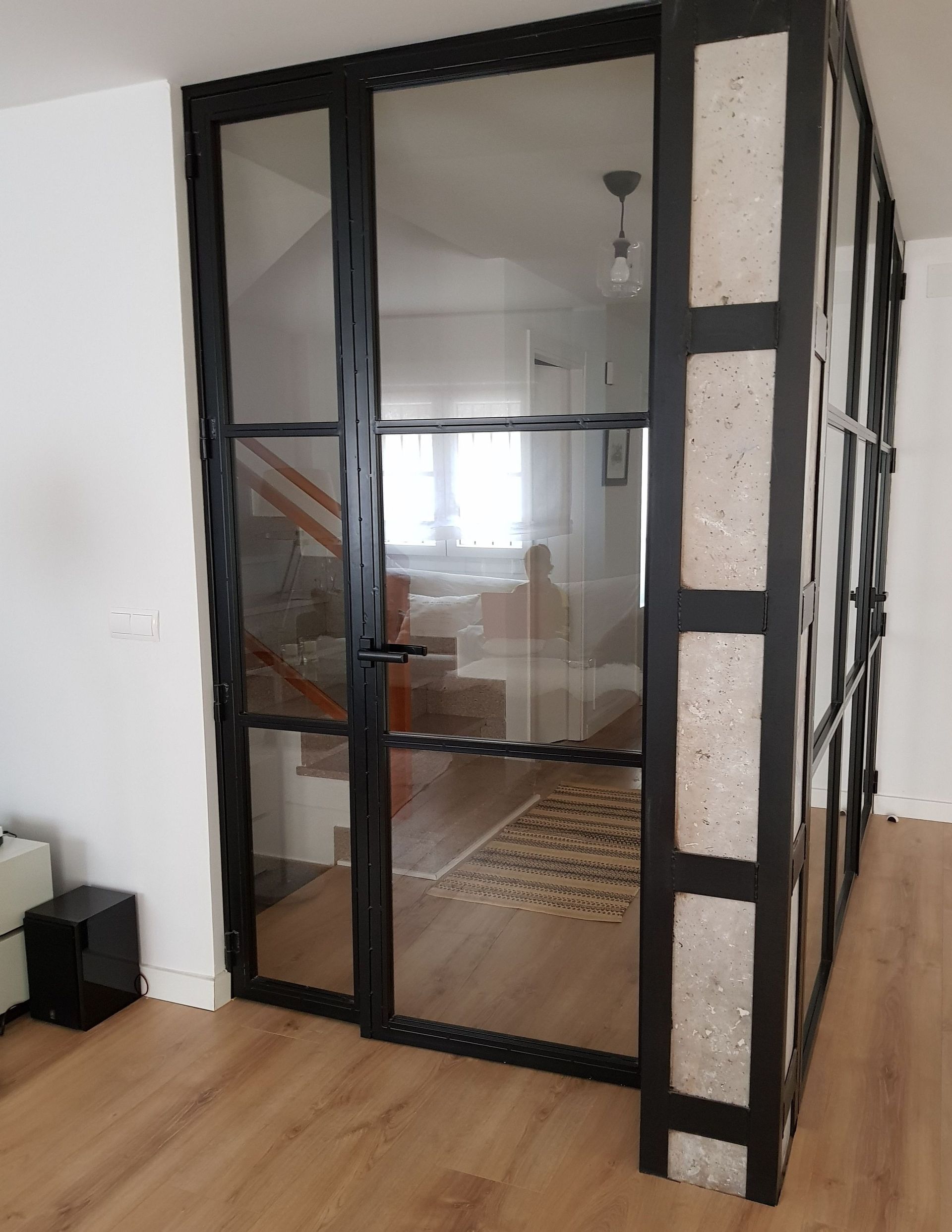 Una sala de estar con una puerta de vidrio que conduce a una escalera.