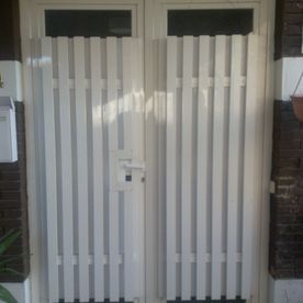 Una puerta blanca está delante de una puerta.