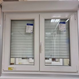 Una ventana blanca con una persiana en una habitación.