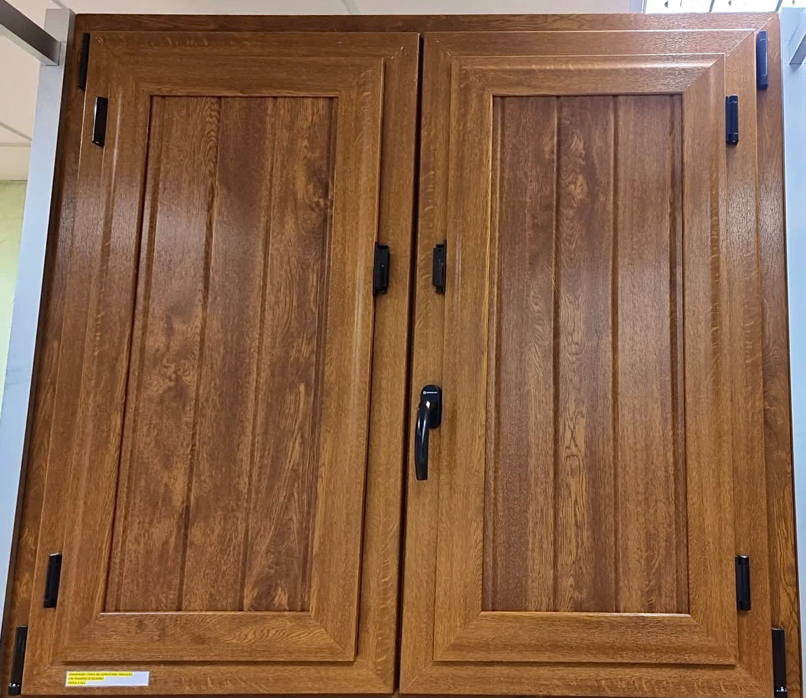 Un par de puertas de armario de madera con tiradores negros.