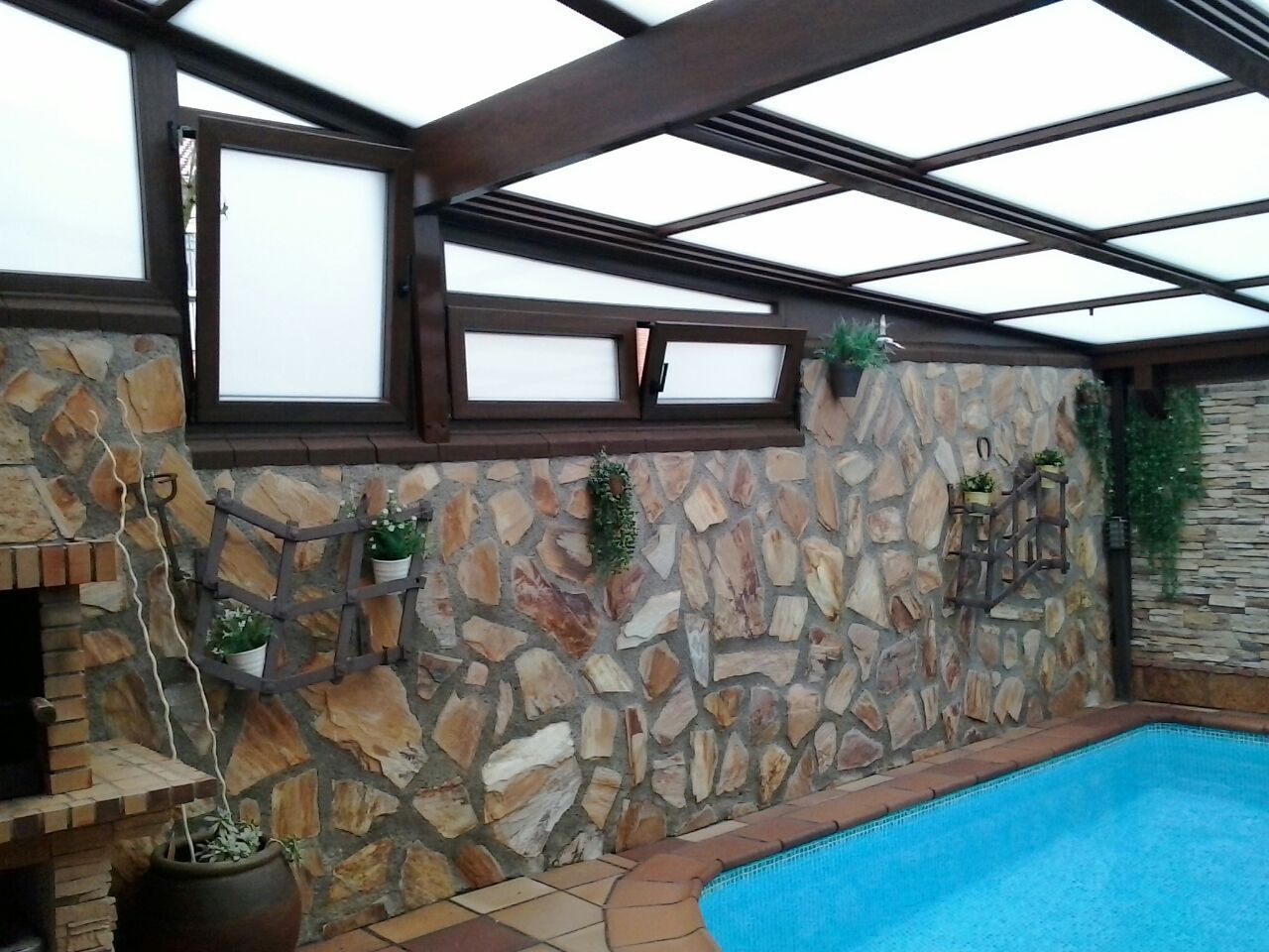 Una piscina con un muro de piedra detrás.