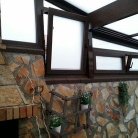 Una pared de piedra con una chimenea y un estante con plantas en macetas.