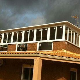 Una casa de ladrillo con muchas ventanas en el techo