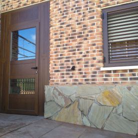 Un edificio de ladrillo con una puerta de madera y una ventana.
