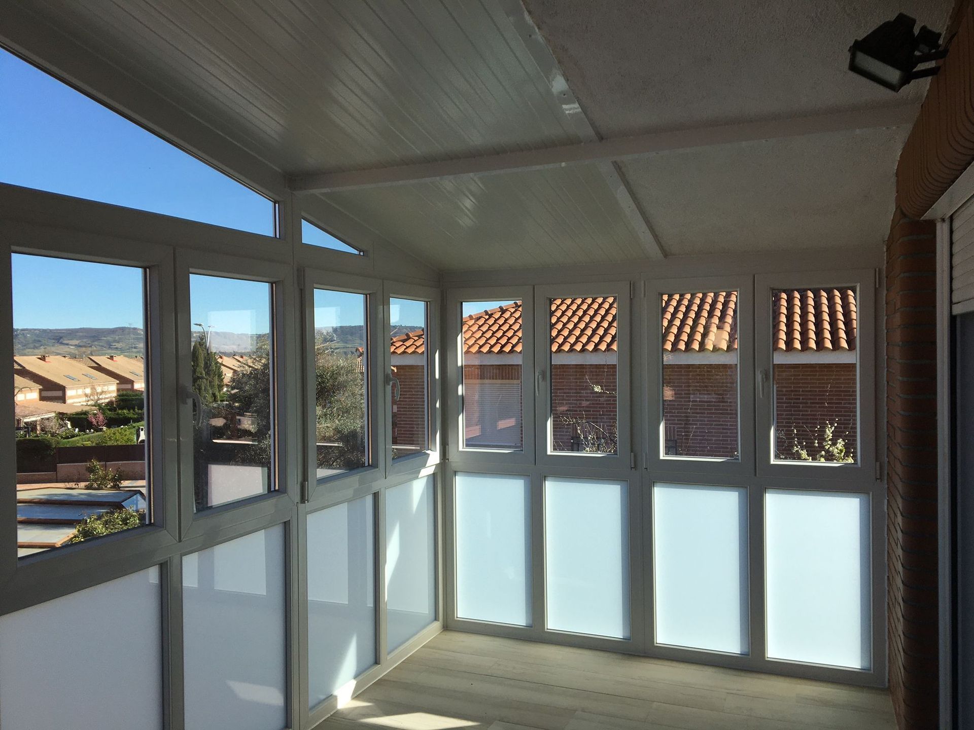 Una habitación con muchas ventanas y un techo al fondo.