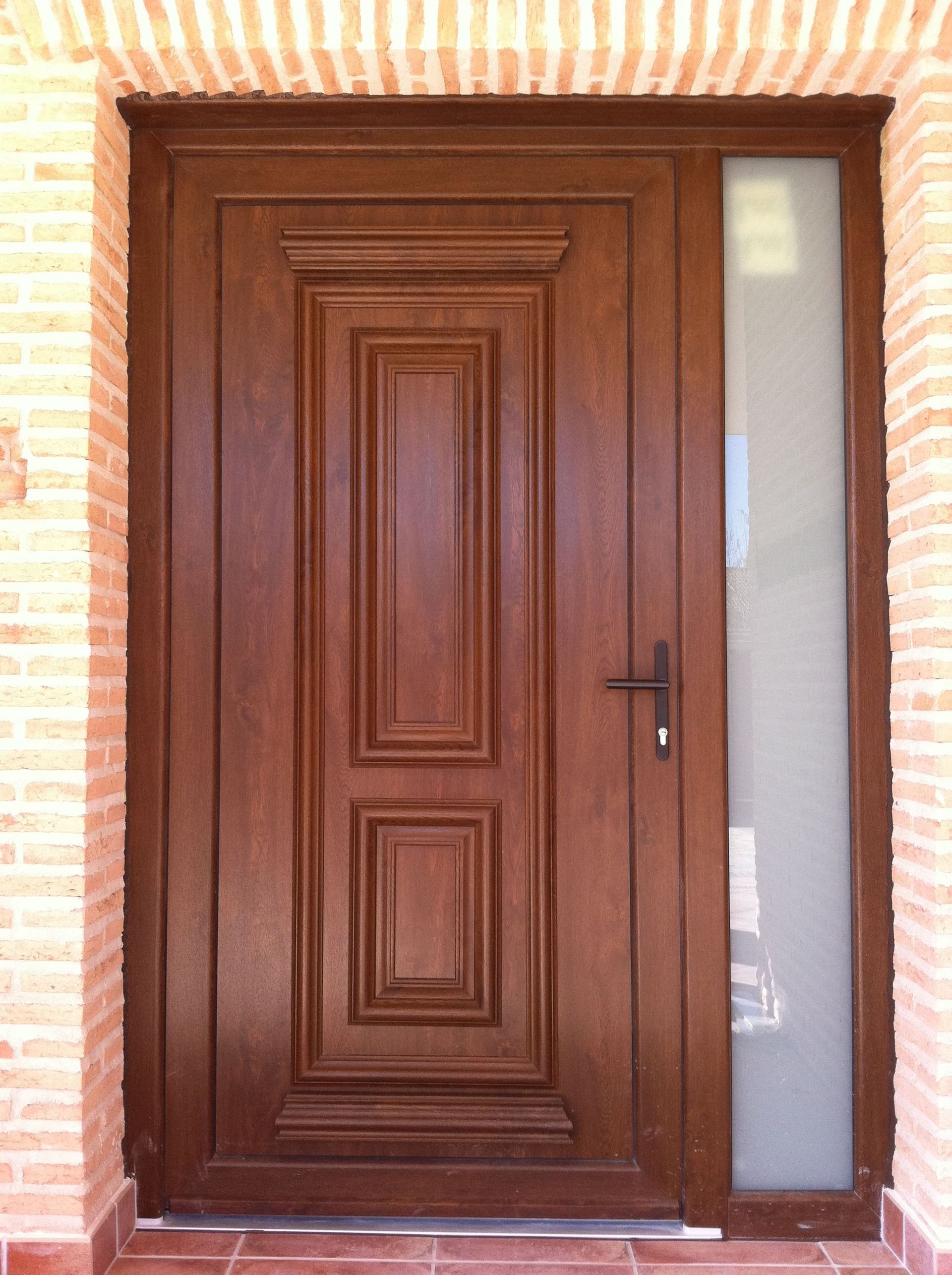 Una puerta de madera con una pared de ladrillos detrás