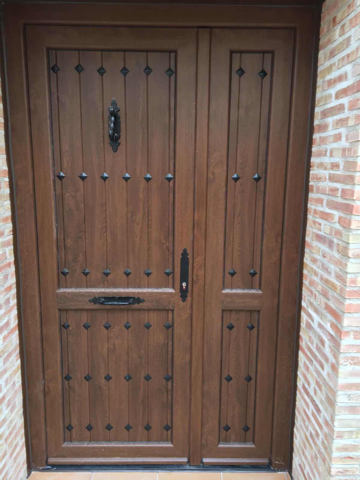 Una puerta de madera está delante de una pared de ladrillos.