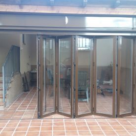 Una habitación con muchas puertas de vidrio y una escalera.