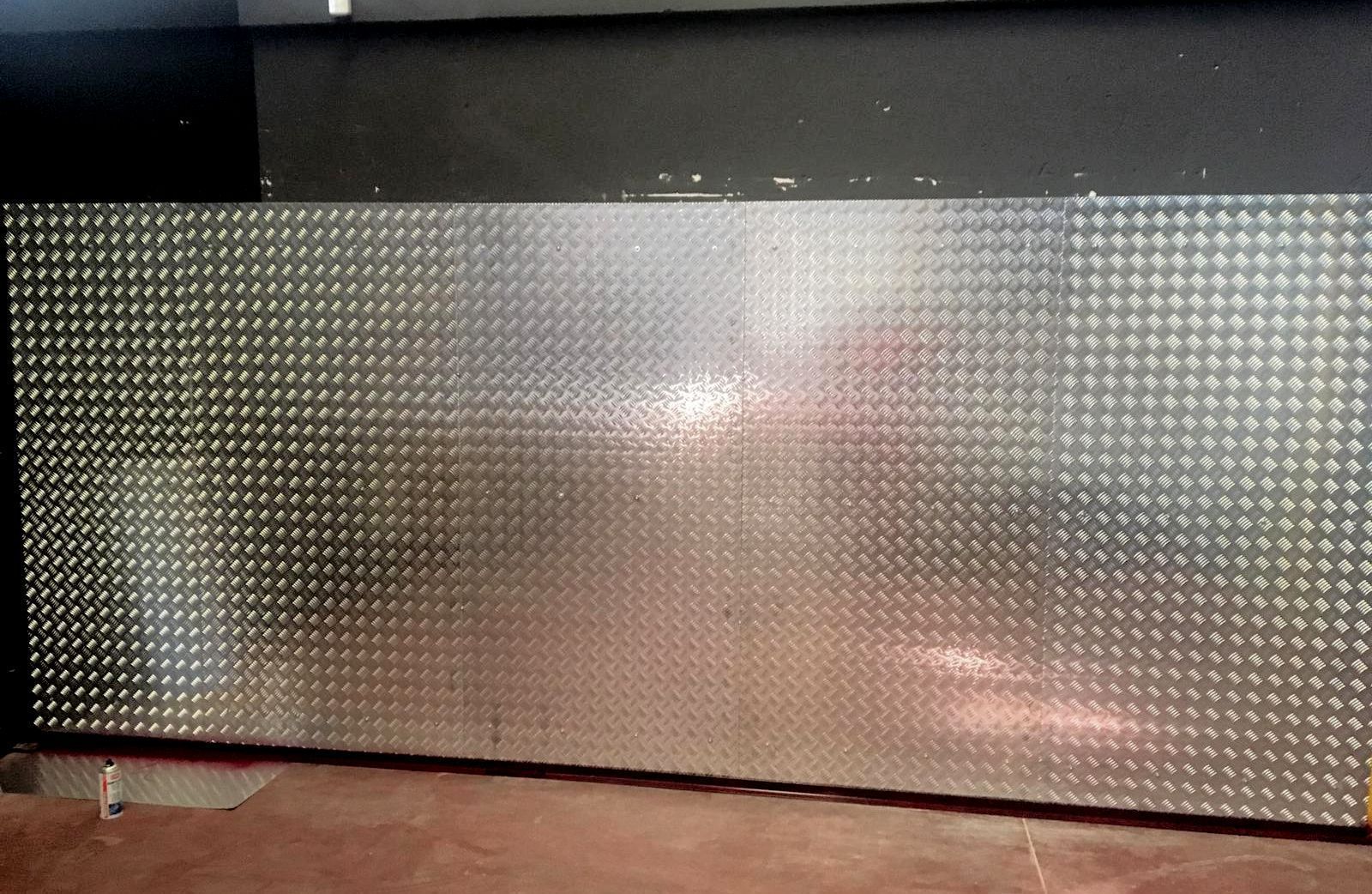 Un gran trozo de metal con agujeros está en el suelo.