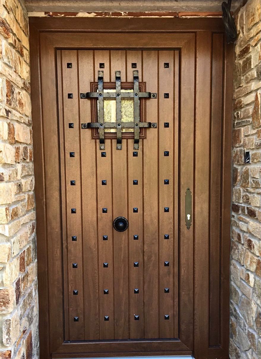 Una puerta de madera con una pared de ladrillos detrás
