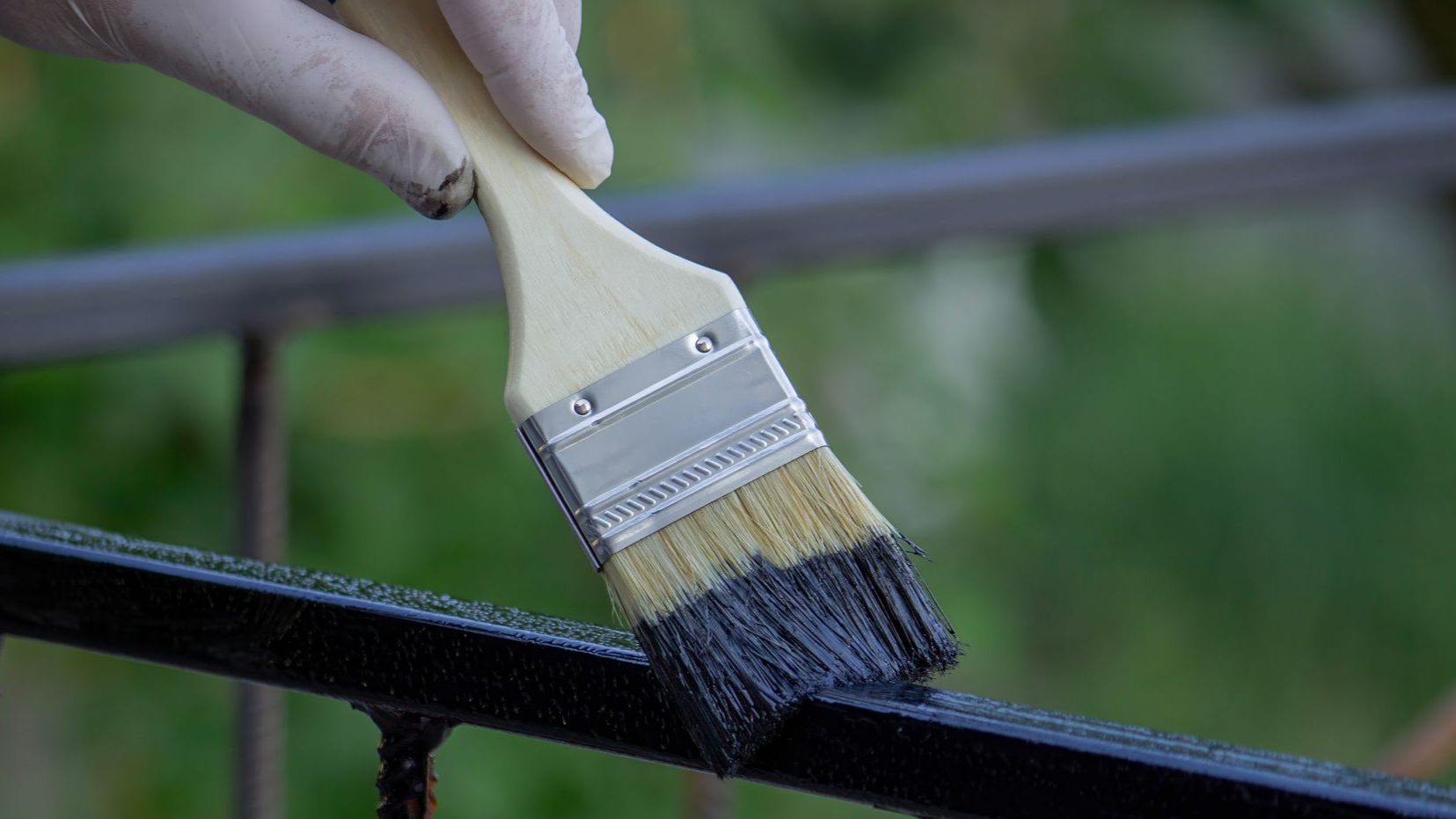 Gros plan sur la main qui tient un pinceau de peinture.