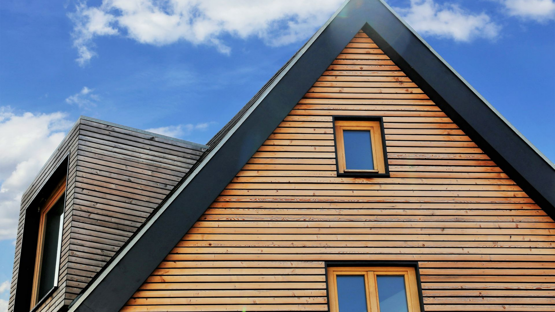 Détail de la façade d'une maison couverte d'un bardage en bois.