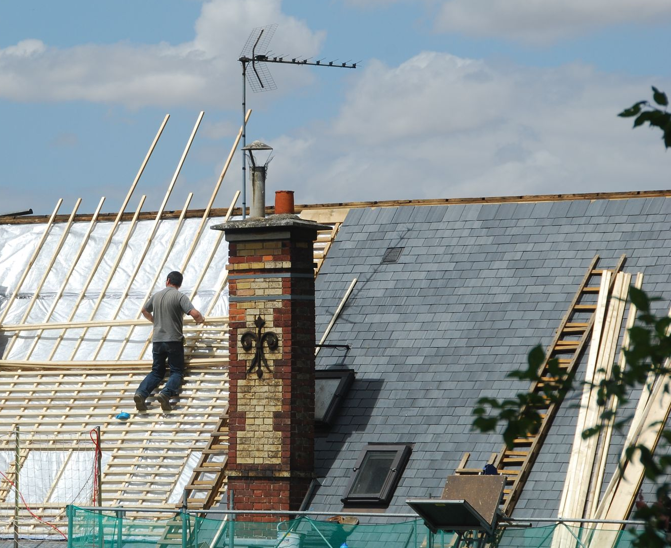 Toiture en ardoise d'une maison particulière avec un professionnel dessus.