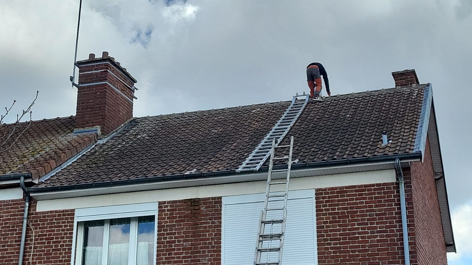 Toiture en tuile couverte de mousses avant le nettoyage.