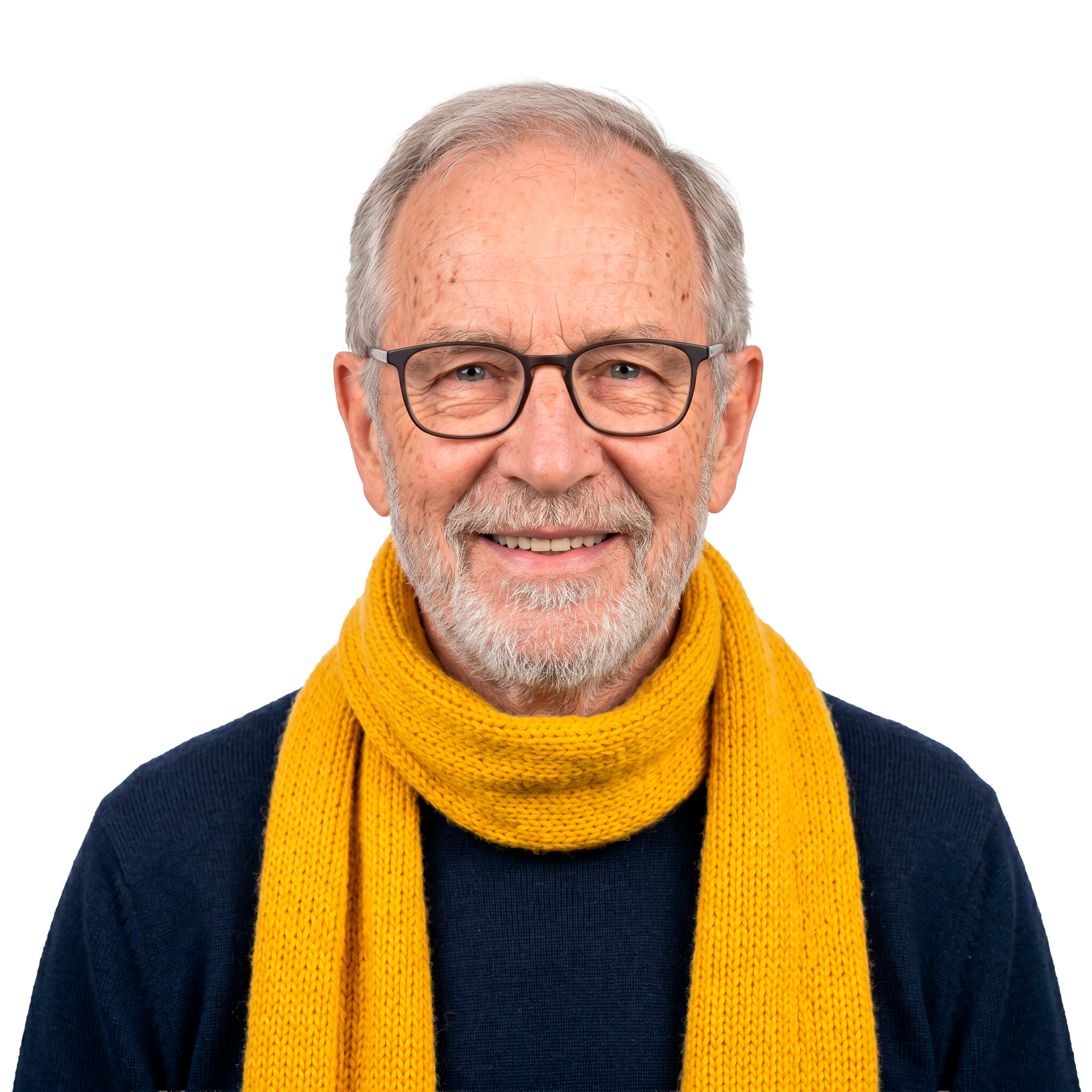 Homme souriant portant des lunettes, une barbe grise, un pull bleu marine et une écharpe jaune vif sur fond blanc