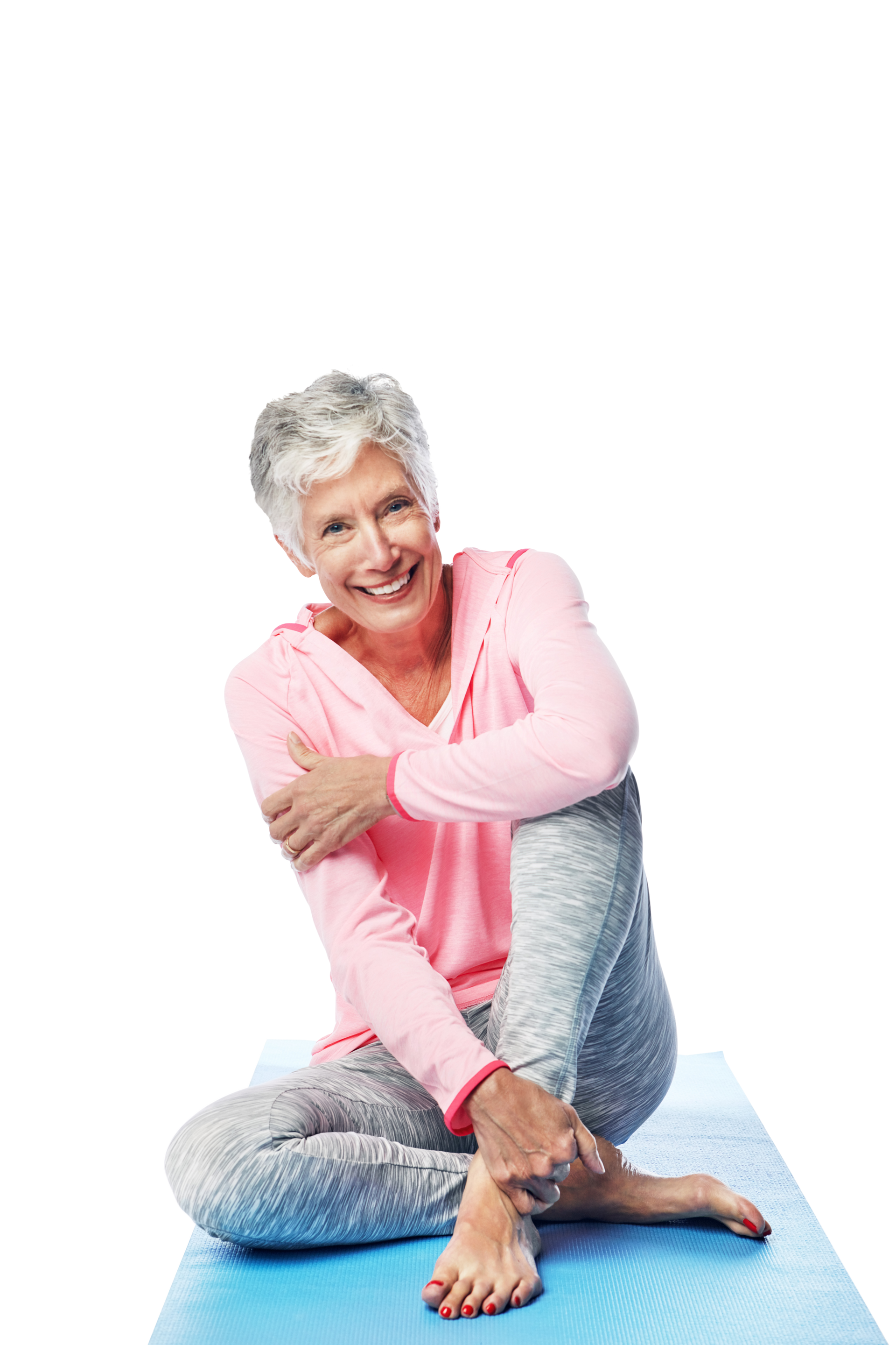 Personne souriante en haut rose et legging gris, assise en position d'étirement sur un tapis bleu