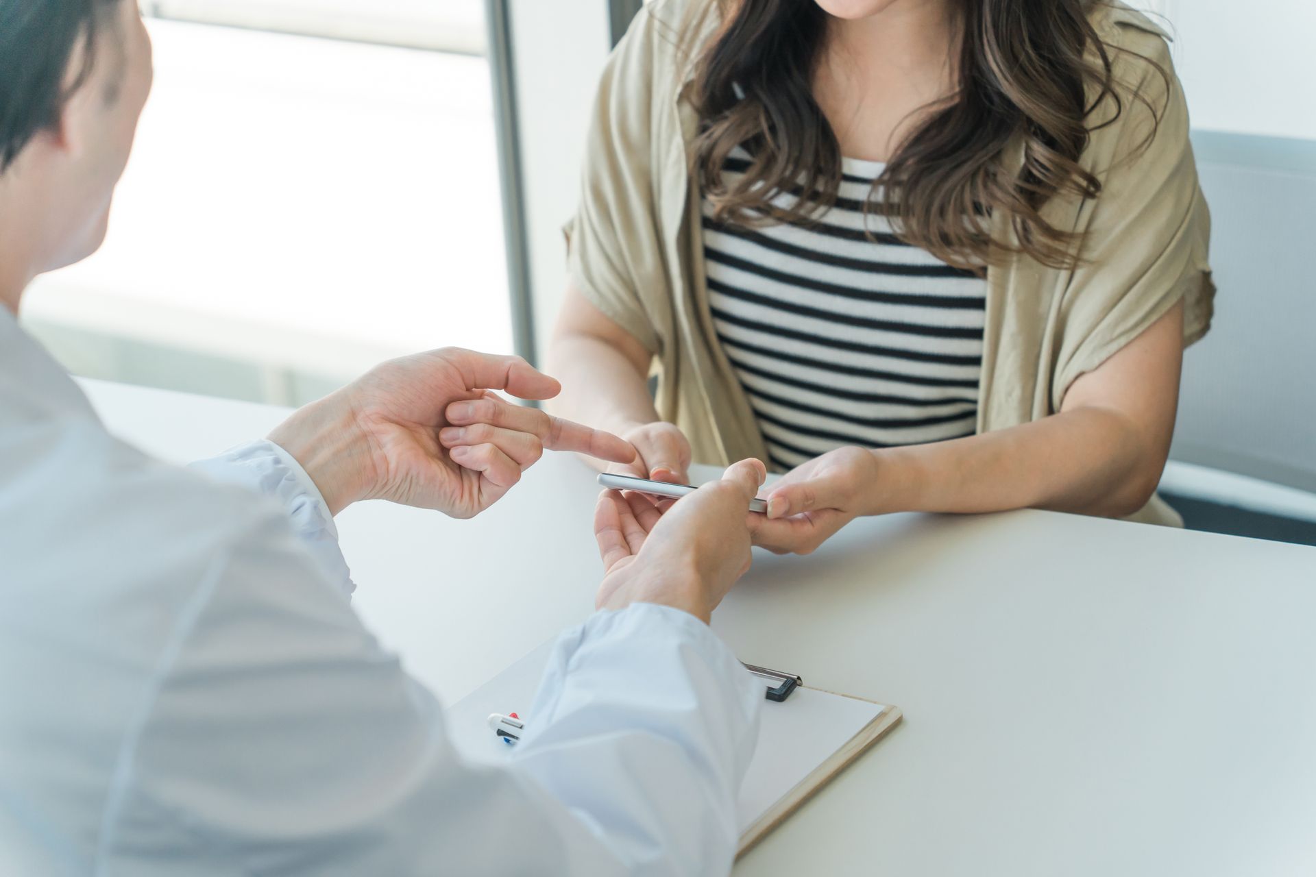 Un médecin remet un flacon de médicament à un patient assis dans un cabinet médical lumineux.
