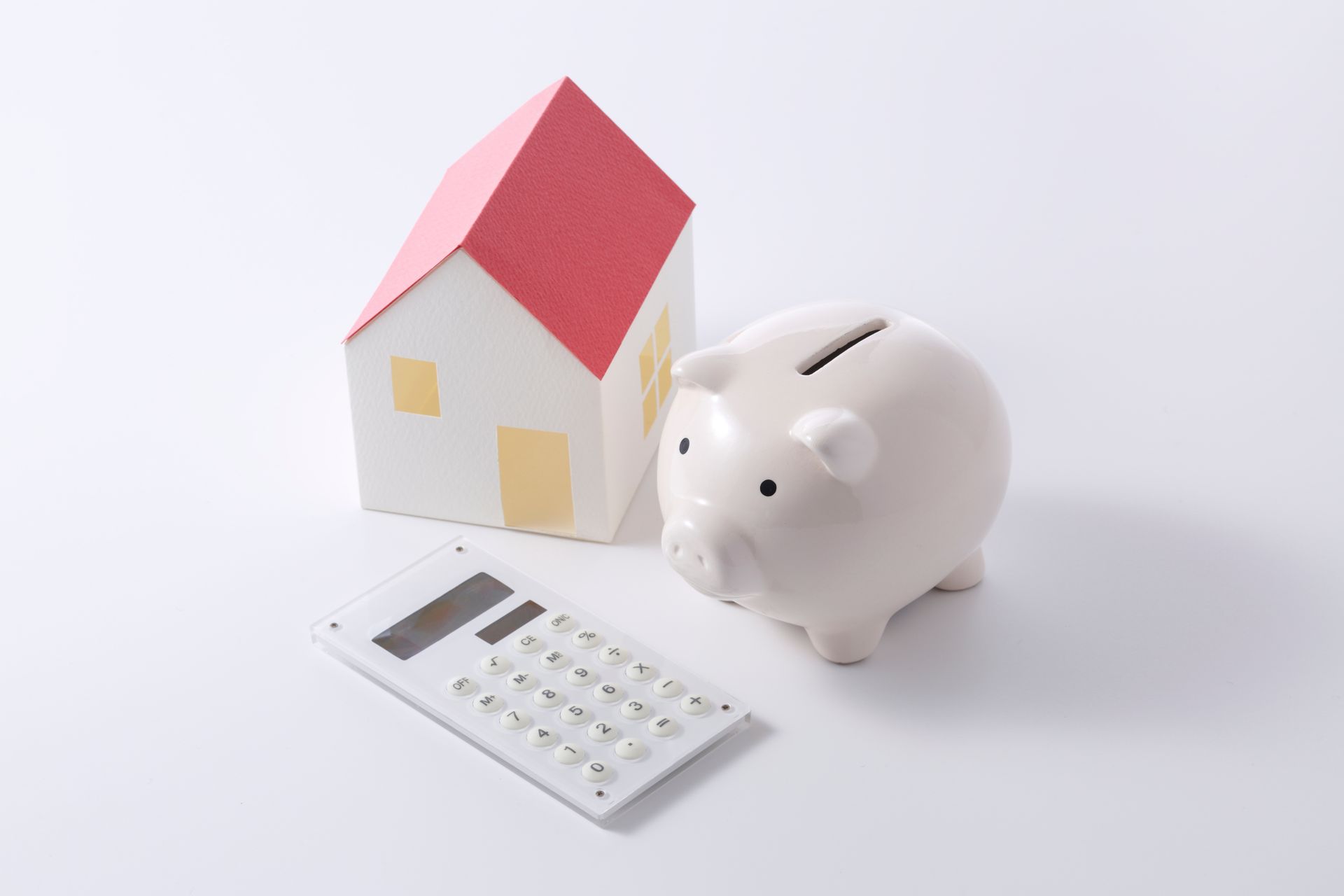 Calculatrice avec maquette de maisonnette et tirelire