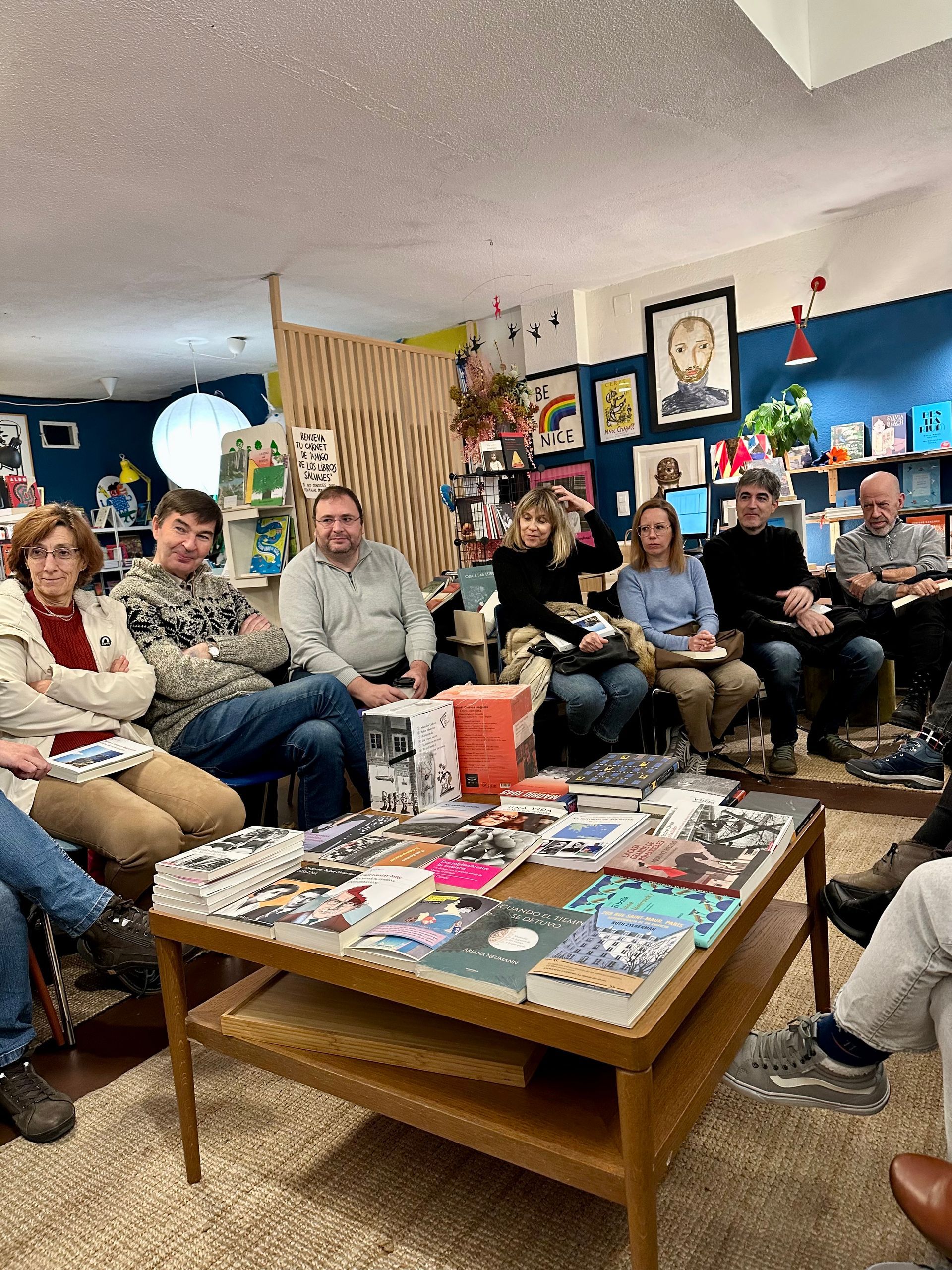 Un grupo de personas está sentada alrededor de una mesa de café en una sala de estar.
