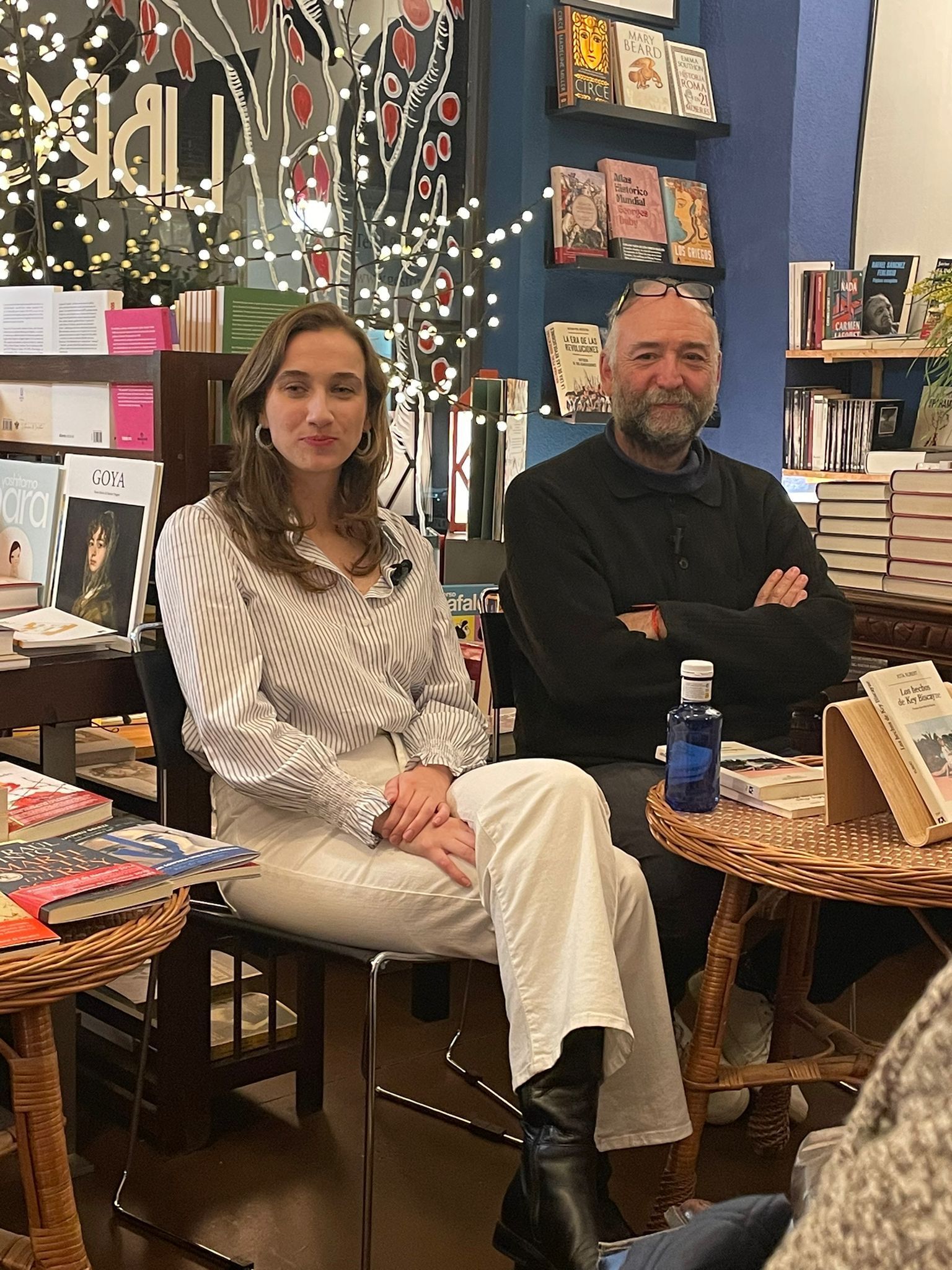 Un hombre y una mujer están sentados uno al lado del otro en una librería.