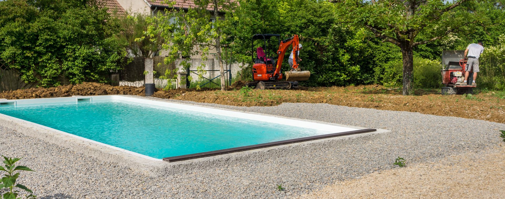 Piscine neuve dans un jardin, avec une pelleteuse