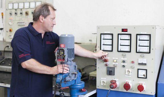 Ein Mann arbeitet in einer Fabrik an einer Maschine.