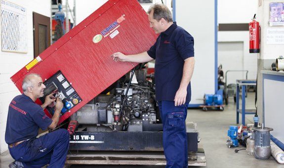 Zwei Männer arbeiten an einer Maschine in einer Fabrik