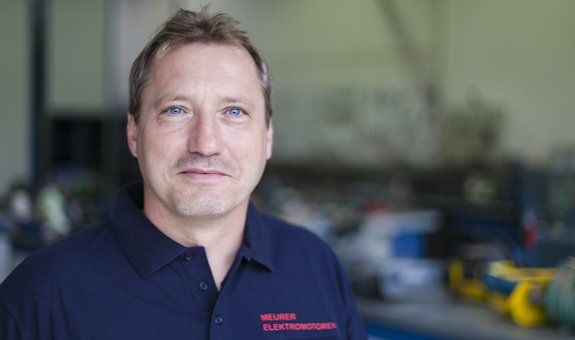 Ein Mann trägt ein blaues Hemd mit dem Wort „Milano“ darauf