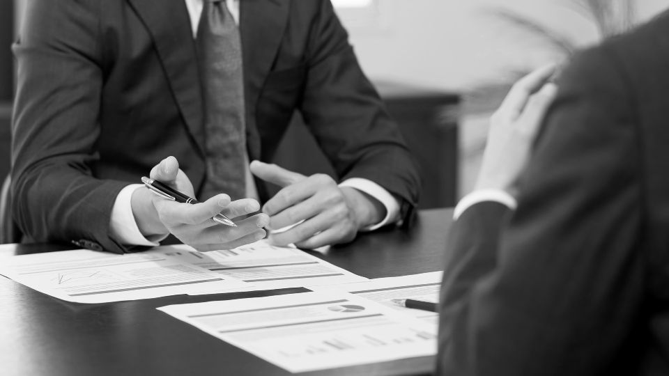Baustelle mit einem gelben Kran, der Materialien hebt. Gebäude im Bau vor einem strahlend blauen Himmel mit einer Wolke.