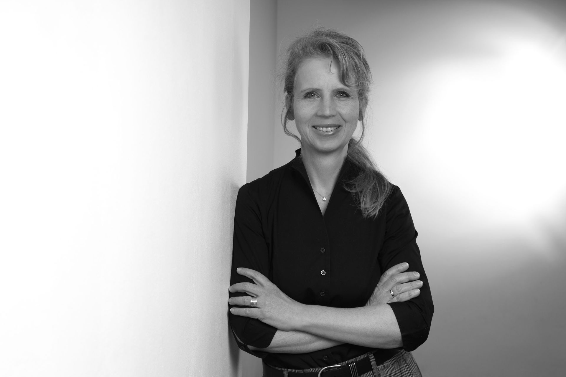 Baustelle mit einem gelben Kran, der Materialien hebt. Gebäude im Bau vor einem strahlend blauen Himmel mit einer Wolke.