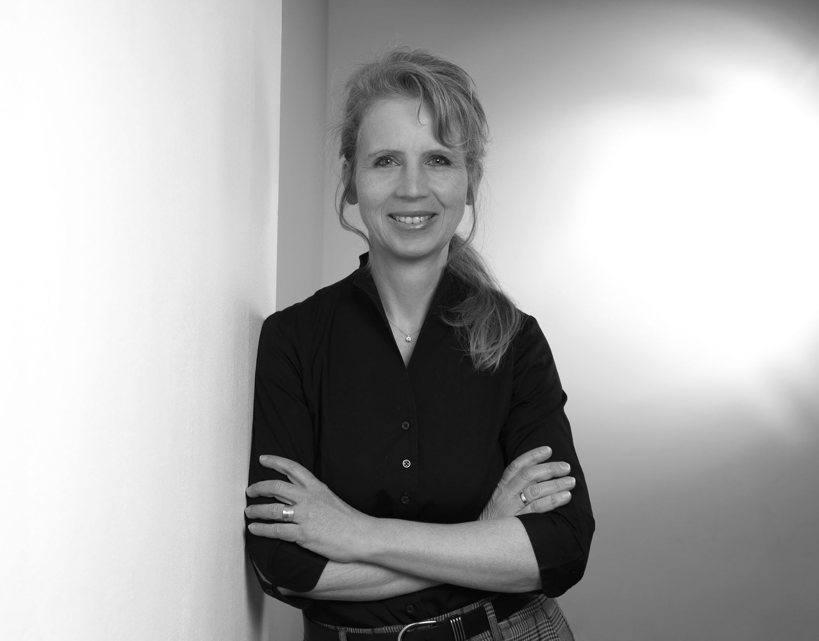 Bauarbeiter auf einer Baustelle betrachten Baupläne. Sonniger Tag, blauer Himmel.