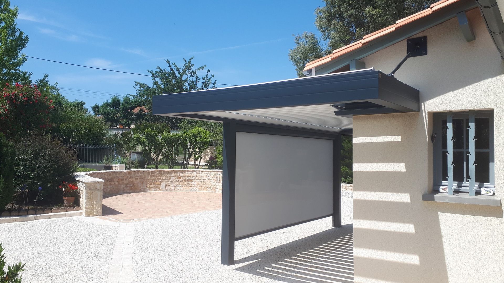 Pergola équipée d'un store zip qui protège la pièce de vie