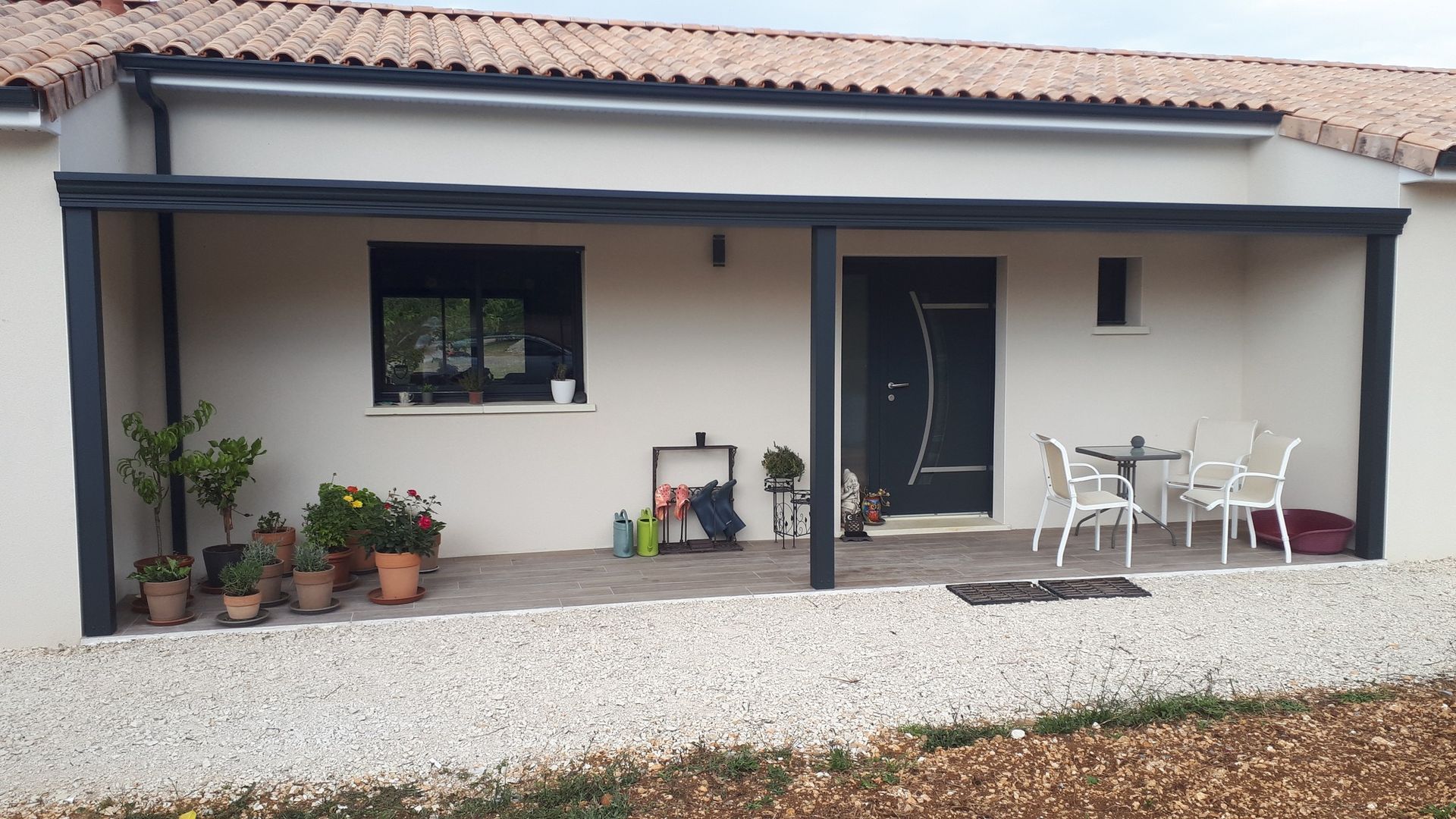 Superbe terrasse avec des fleurs , un salon de jardin sous une pergola