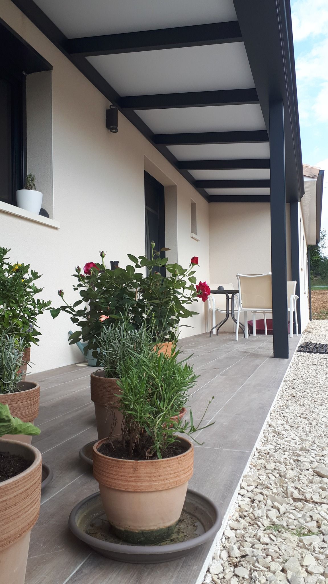 Devanture d'une maison avec une pergola qui longe l'habitation