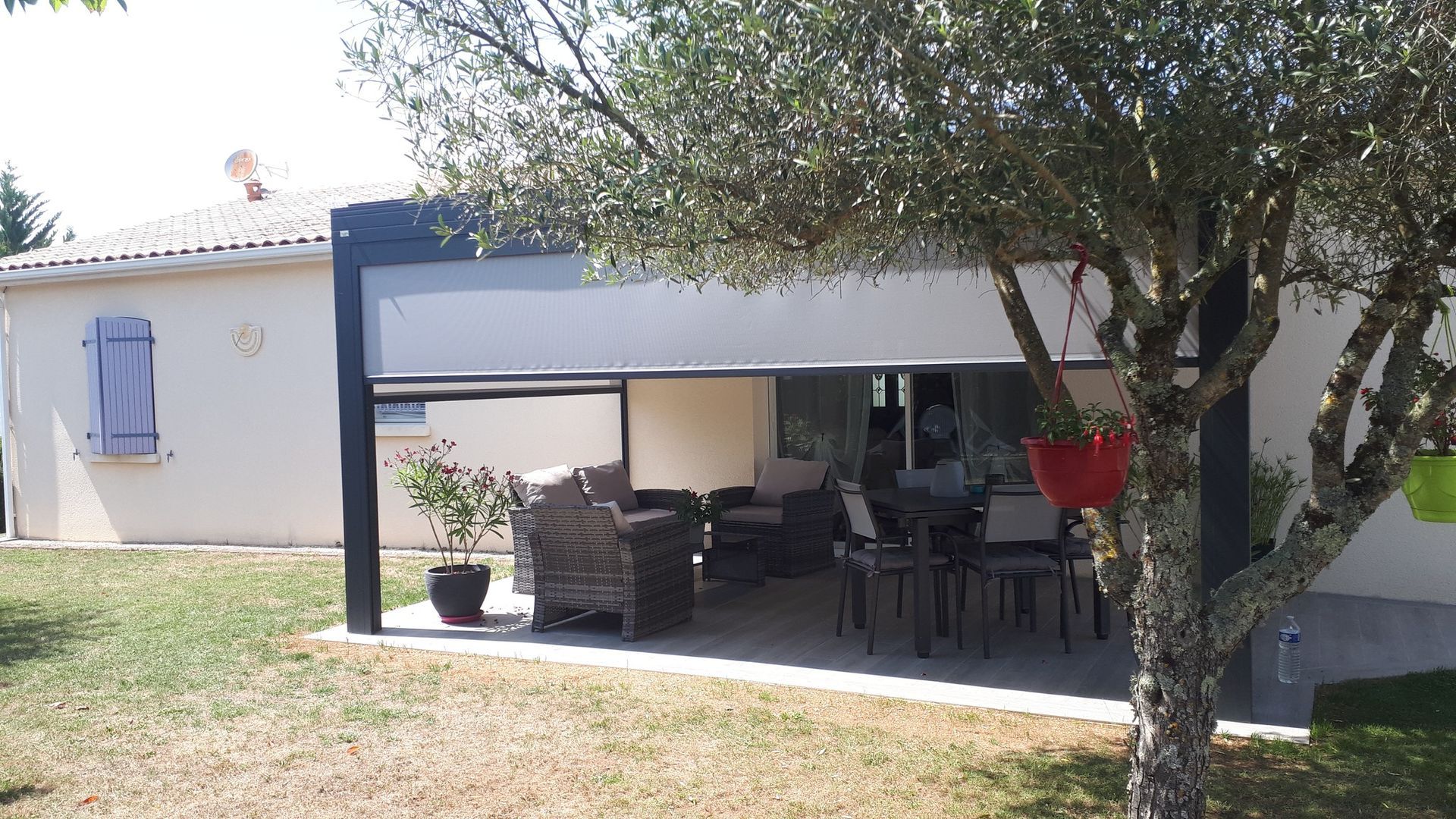 Pergola avec un salon de jardin et une moustiquaire blanche