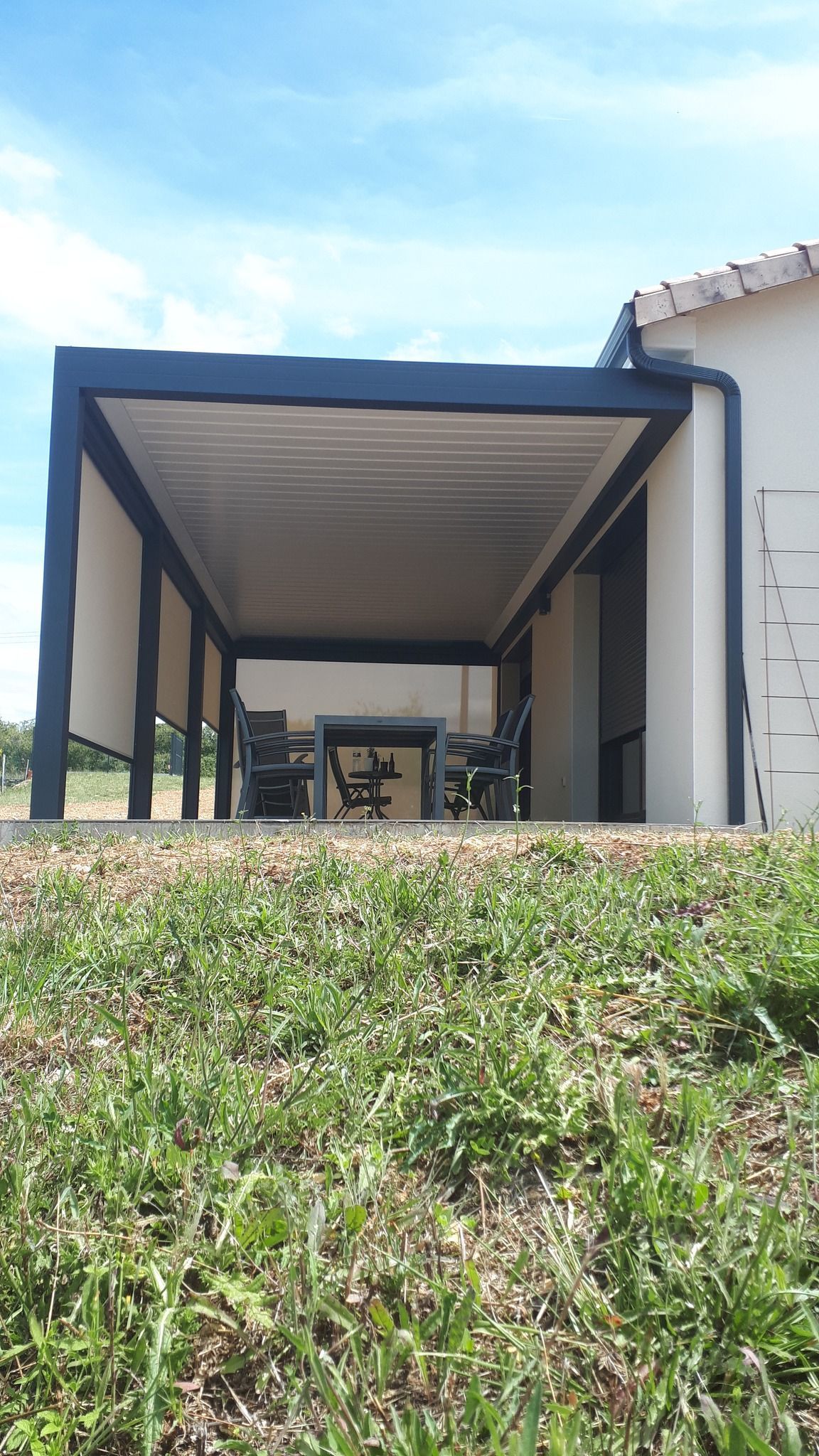 Pergola à toit fixe adossée à la façade d'une maison