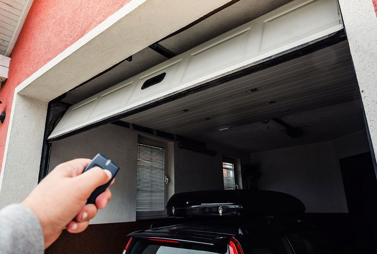 Homme qui ouvre son garage avec une télécommande