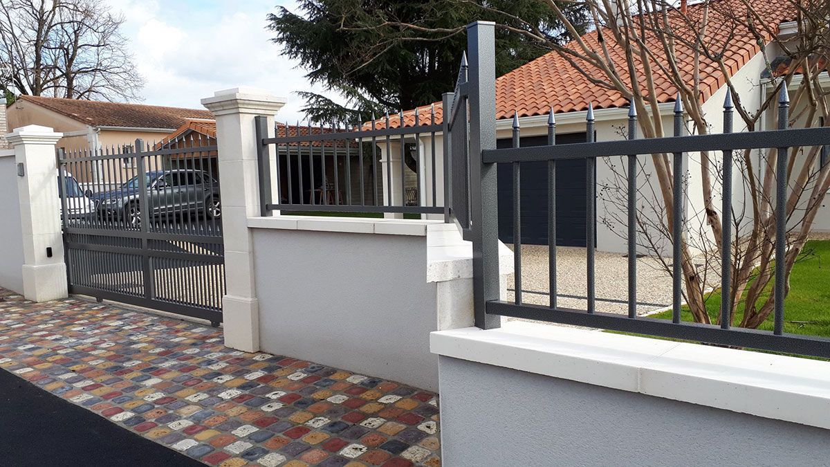 Muret d'une entrée de maison avec clôture en forme de pic