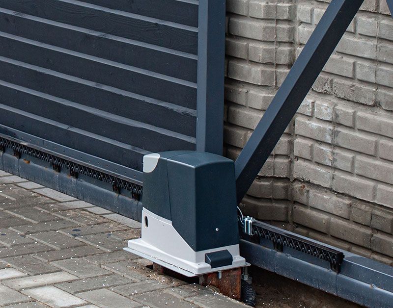 Zoom sur un portail noir avec son moteur