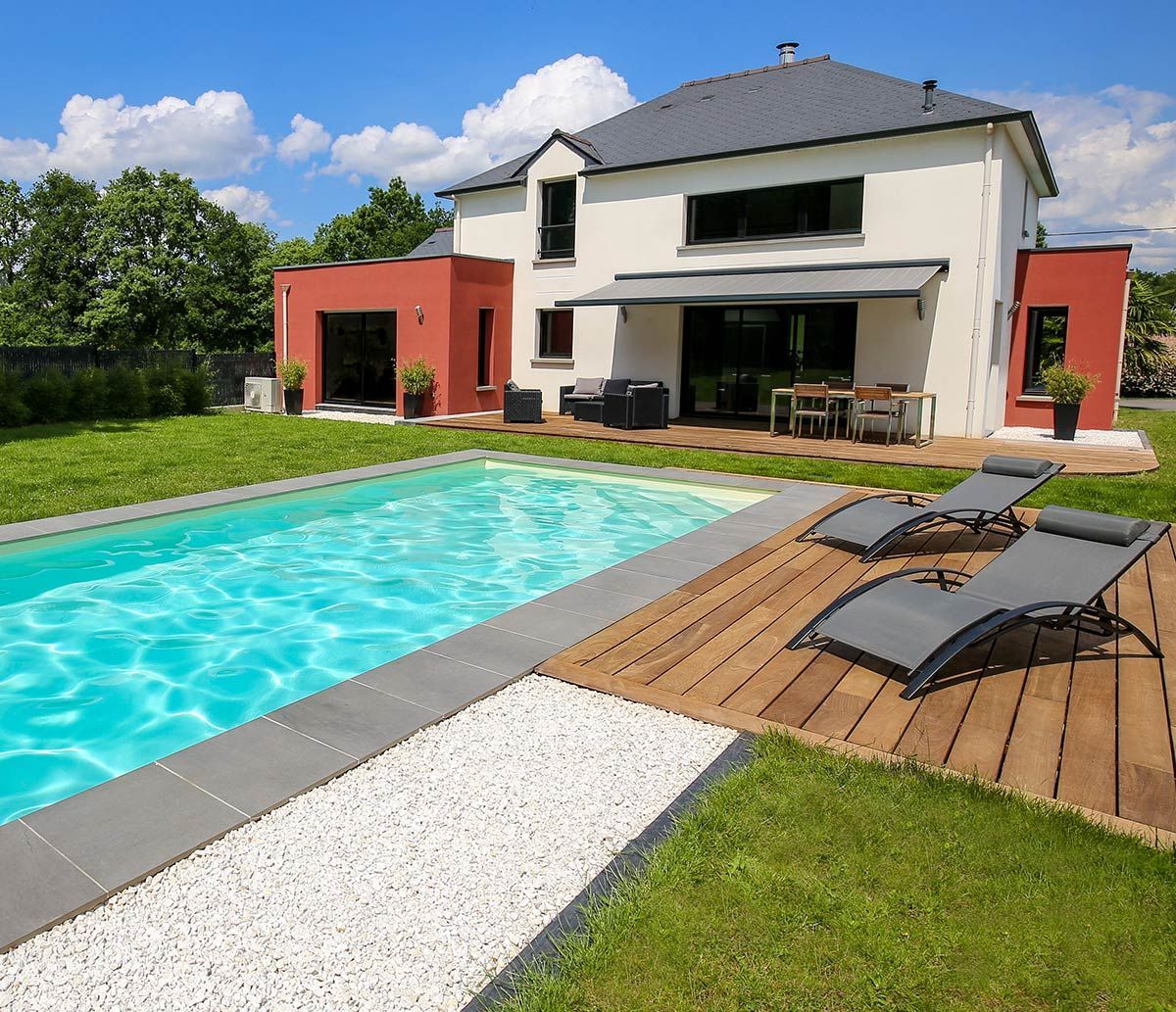 Maison avec une piscine et une terrasse comportant un store banne