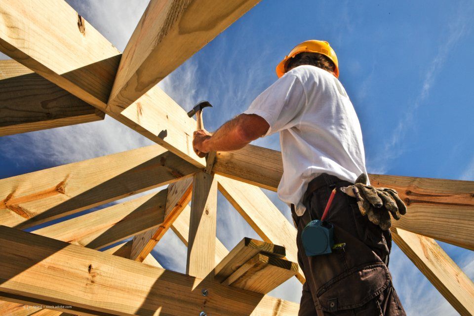 Mitarbeiter von Rüger Holzbau zimmert Dachstuhl