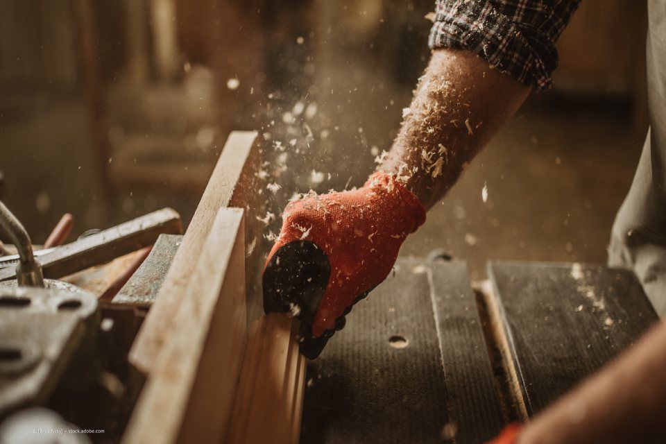 Mitarbeiter von Rüger Holzbau bearbeitet Holz