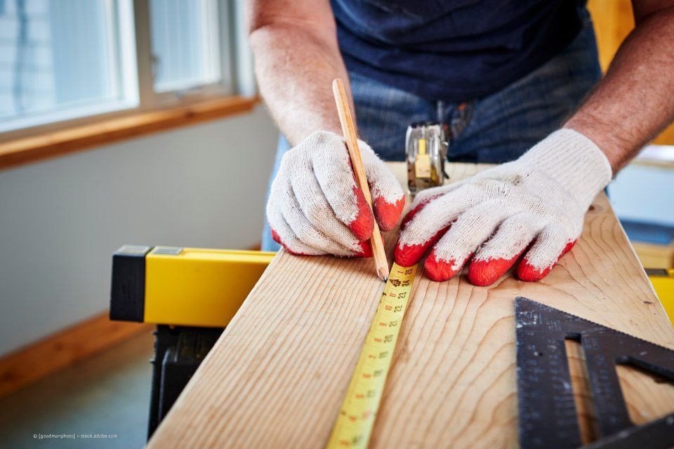 Mitarbeiter von Rüger Holzbau bearbeitet Holz