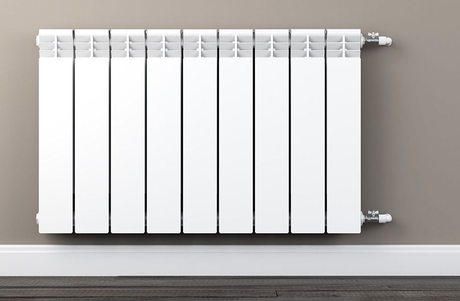 Un radiador blanc està penjat a la paret d'una habitació.