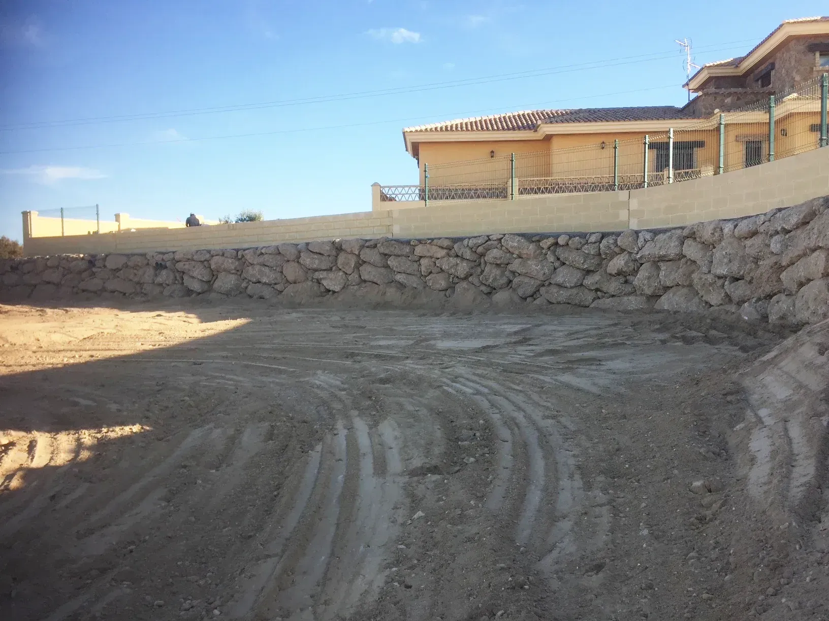Se está construyendo un muro de piedra en la cima de una colina de tierra.