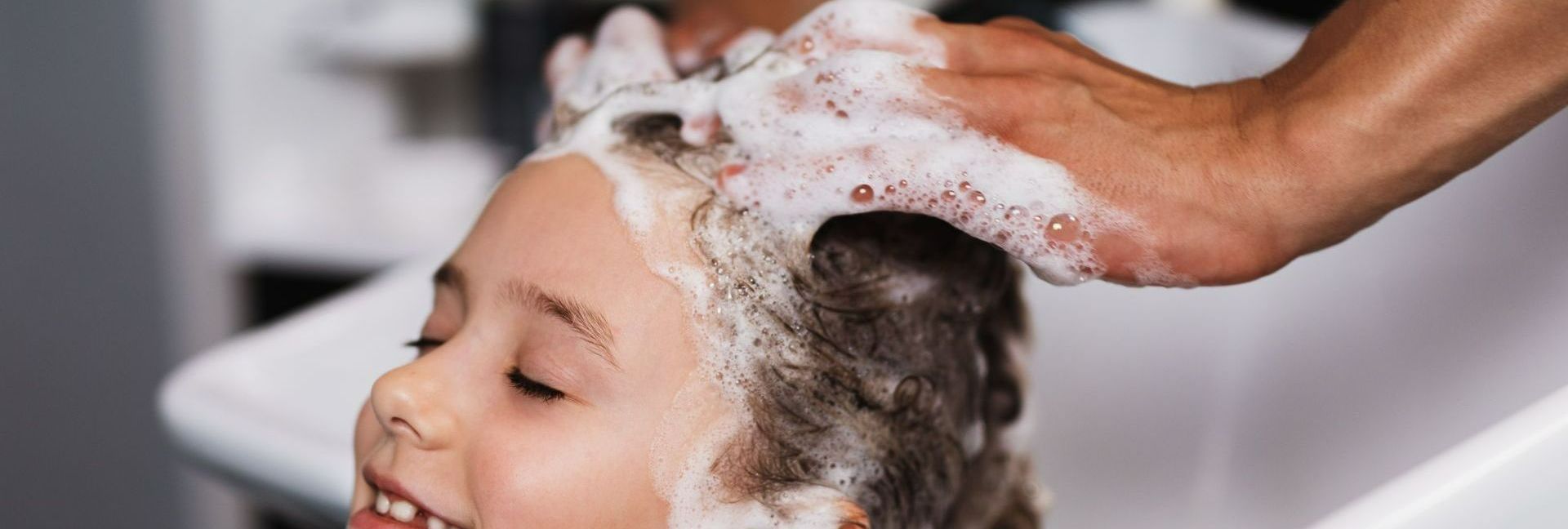 Un enfant se faisant laver les cheveux.
