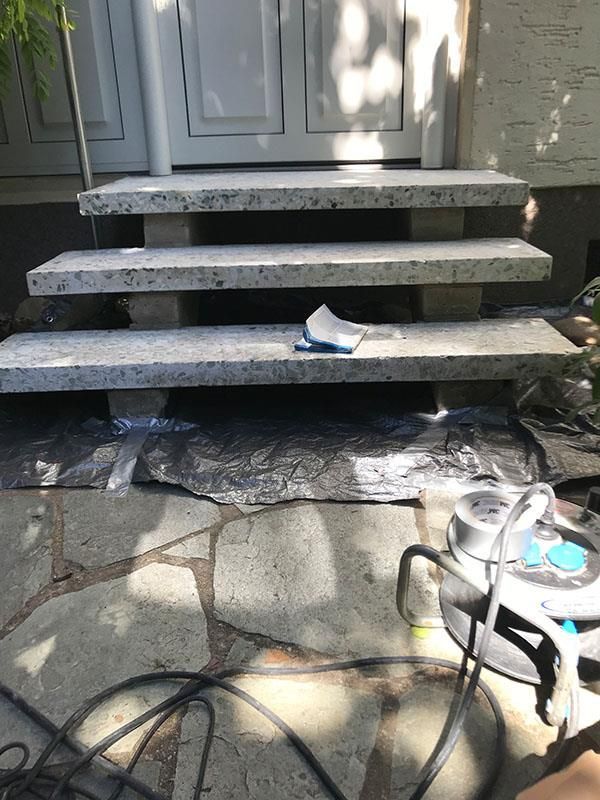 Ein Staubsauger steht neben einer Treppe auf dem Boden.