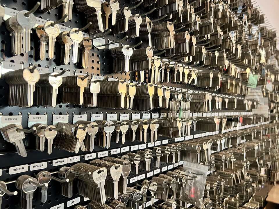 Un trousseau de clés est accroché au mur d'un atelier de serrurerie.